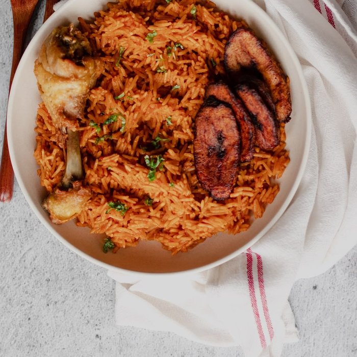 Jollof rice with peppered chicken and fried plantain